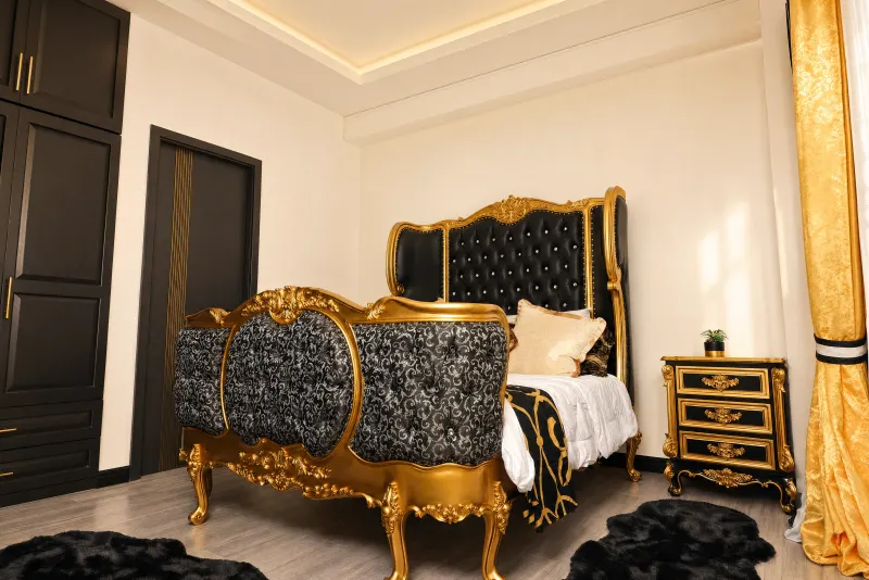 Gilded bed against black joinery